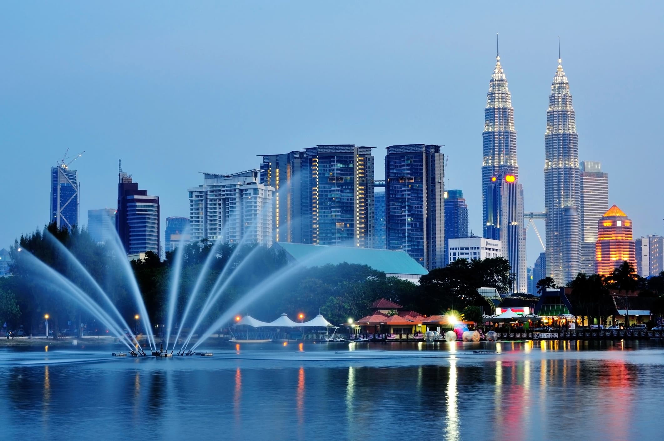 Kuala Lumpur city skyline reflected in the KLCC lake at dusk